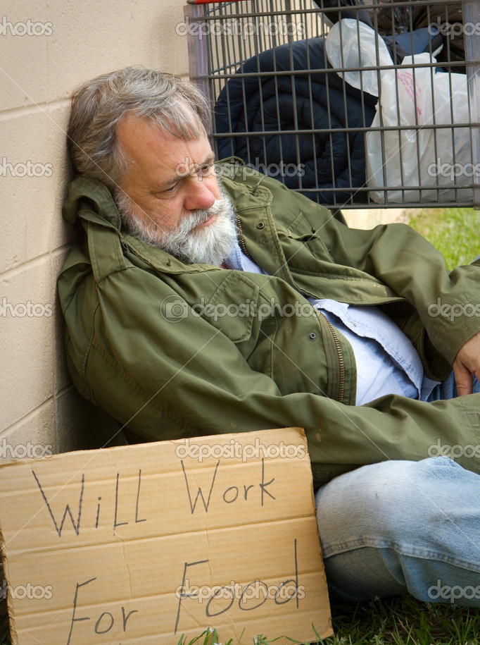 Homeless and hopeless man in an old army jacket waits for a handout.